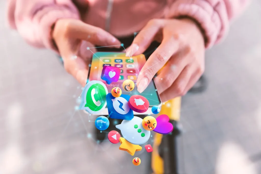 manos sosteniendo celular con iconos de redes sociales